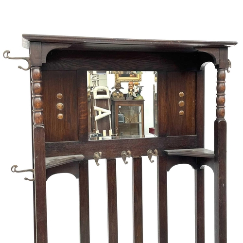 1913 - An oak hallstand, with central mirror and incorporating two stick stands, height 187cm, width 100cm,... 