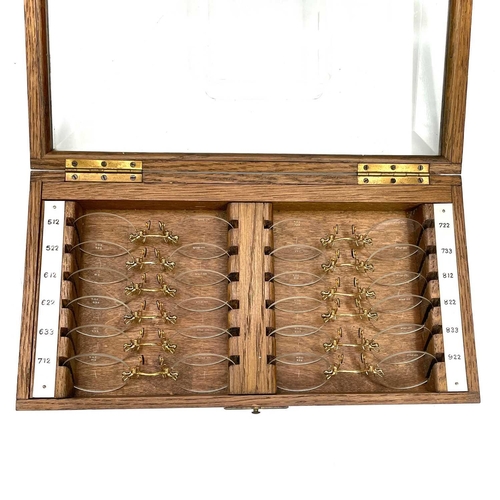 199 - A set of twelve Opticians lenses, with gilt metal fittings, contained in a glazed top oak case, widt... 