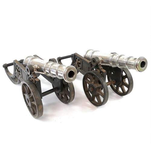 201 - A pair of model cannons, with silver plated finish on cast iron carriages, width 44.5cm (2).