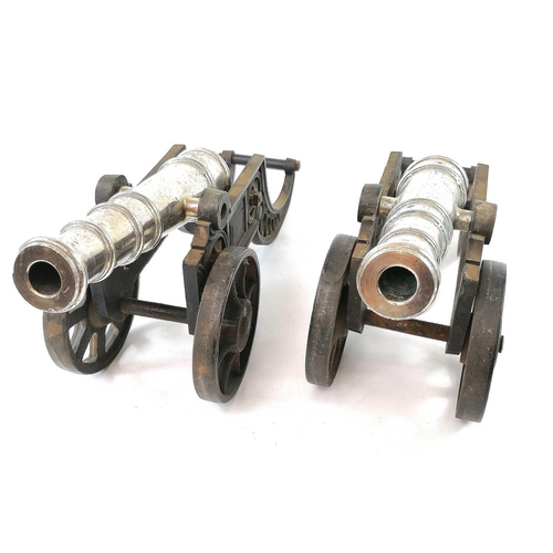 201 - A pair of model cannons, with silver plated finish on cast iron carriages, width 44.5cm (2).