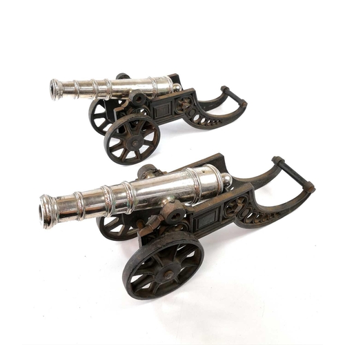 201 - A pair of model cannons, with silver plated finish on cast iron carriages, width 44.5cm (2).