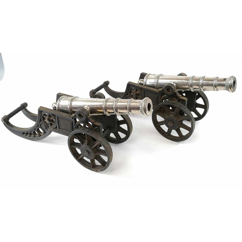 201 - A pair of model cannons, with silver plated finish on cast iron carriages, width 44.5cm (2).