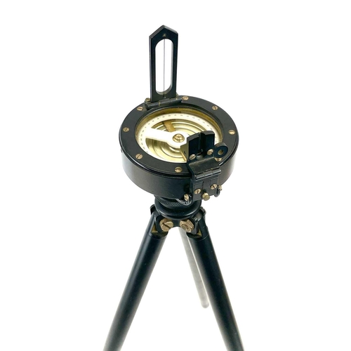 215 - A Surveyor's prismatic compass, diameter 8cm, together with a folding tripod, leather cased.