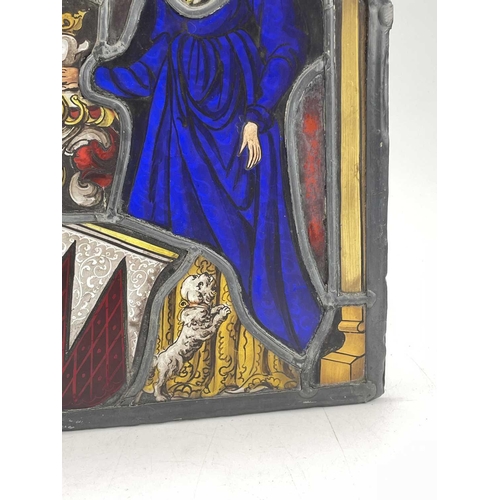 227 - A stained glass panel, 17th/18th century, depicting a lady in a blue dress with a dog at her feet, 3... 