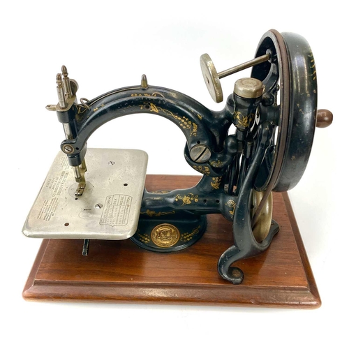 236 - A Willcox & Gibbs chain stitch sewing machine, circa 1885, with a small box of fittings and pine car... 