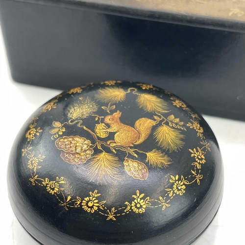 241 - A small circular Russian papier mache lacquer box decorated with a squirrel in a pine tree, diameter... 