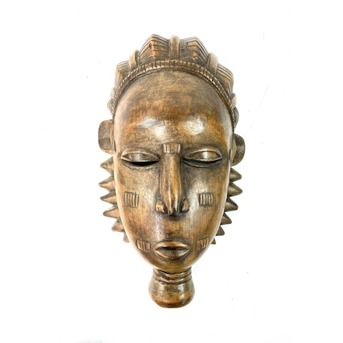 257 - An African wood carved Igbo mask painted in polychrome colours, height 31cm, together with another f... 