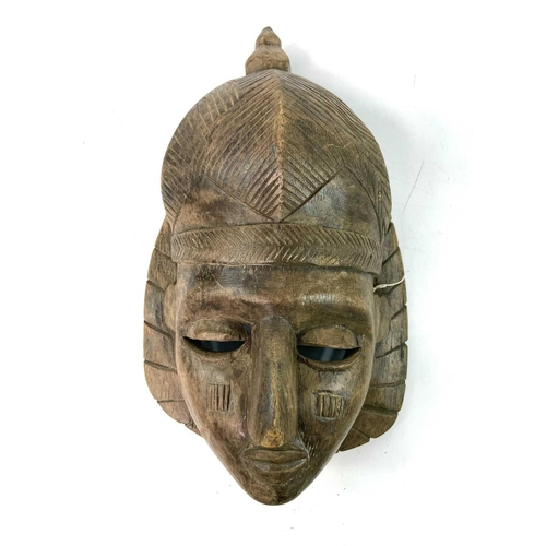 257 - An African wood carved Igbo mask painted in polychrome colours, height 31cm, together with another f... 