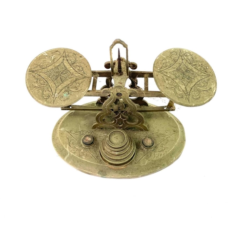 277 - A Victorian engraved gilt metal postal balance, with weights, width 17.5cm, together with two Bakeli... 