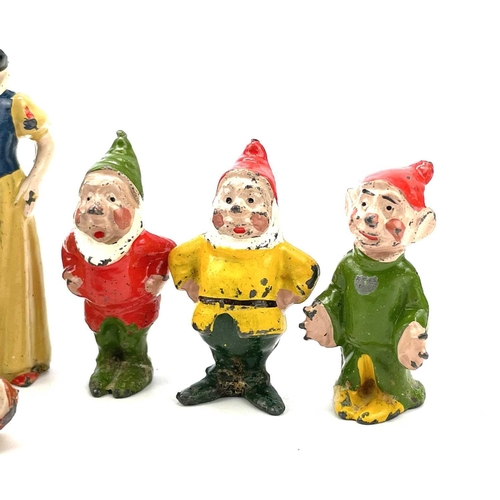 31 - A painted lead Snow White figure, height 6cm, and the seven Dwarves.