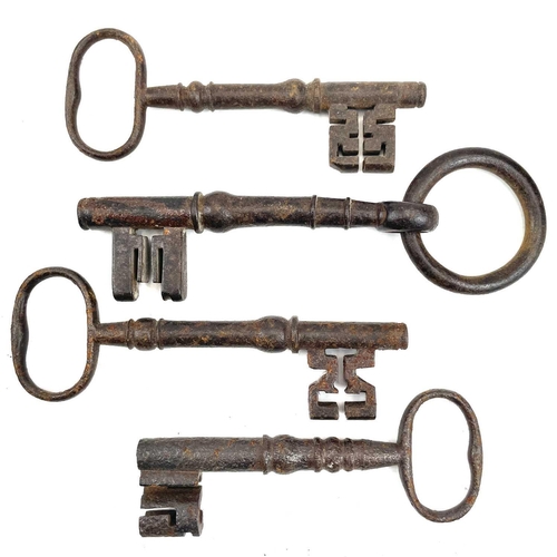 32 - An 18th century iron key, with integral folding ring, length 15cm, together with three other iron ke... 