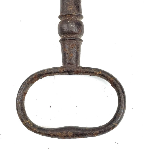 32 - An 18th century iron key, with integral folding ring, length 15cm, together with three other iron ke... 