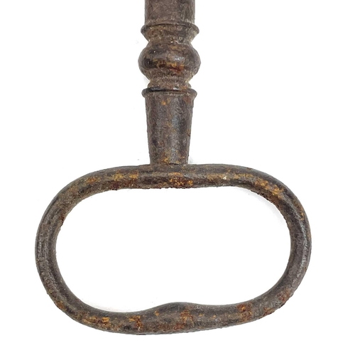 32 - An 18th century iron key, with integral folding ring, length 15cm, together with three other iron ke... 