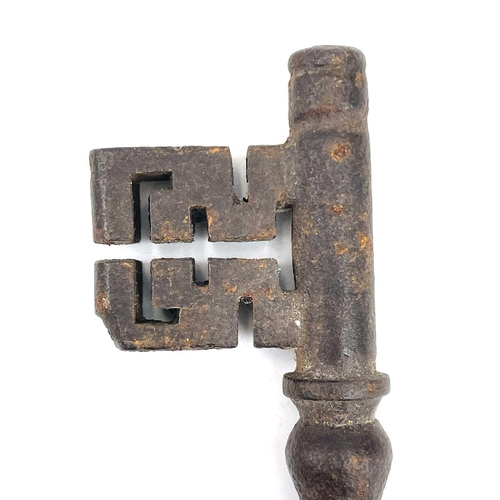 32 - An 18th century iron key, with integral folding ring, length 15cm, together with three other iron ke... 