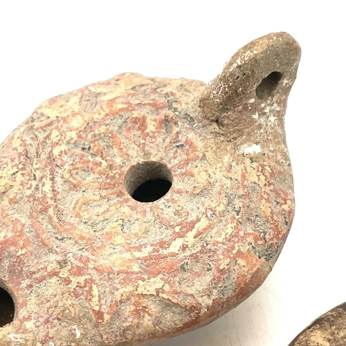 41 - A Roman terracotta oil lamp moulded with wheat design diameter 10cm together with another Roman terr... 