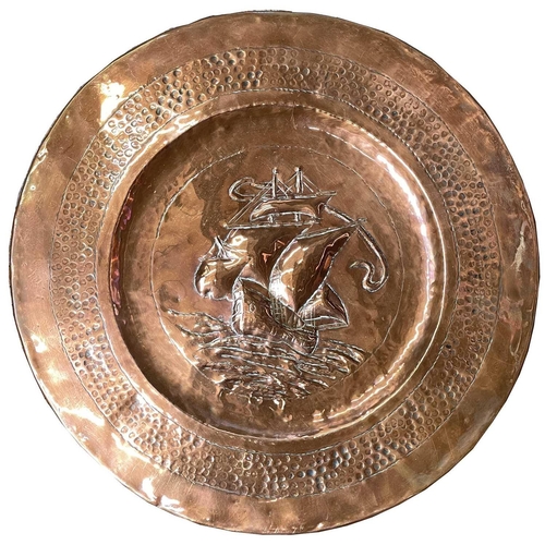 44 - A copper charger, possibly Newlyn, repousse decorated with a galleon to the centre, with attached pa... 