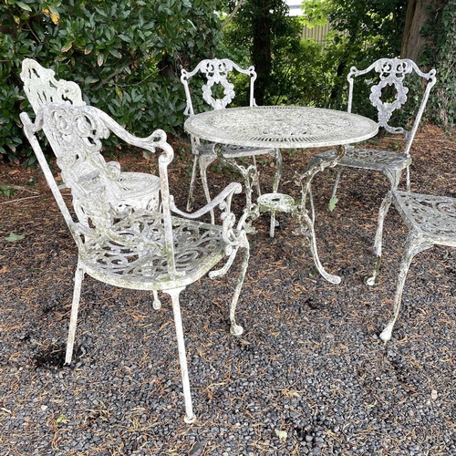 613 - A cast metal garden table and five chairs in the Victorian style. Table height 69cm diameter 80cm