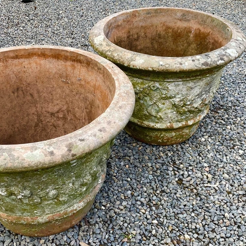 614 - Two matched terracotta urns moulded with floral swags, height 49cm diameter 61.5cm