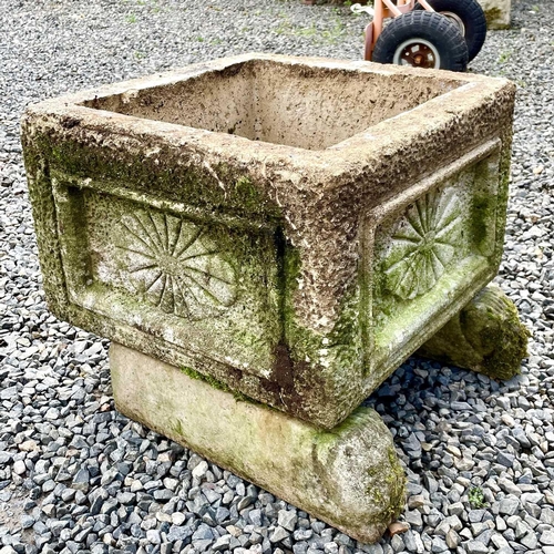 617 - A reconstituted stone rectangular planter with indented moulded decoration raised upon a pair of lio... 