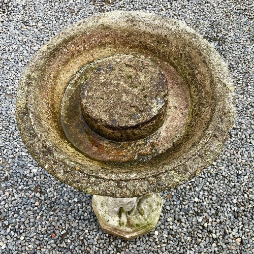 619 - A reconstituted stone garden bird bath the circular top supported bya pedestal base moulded with the... 