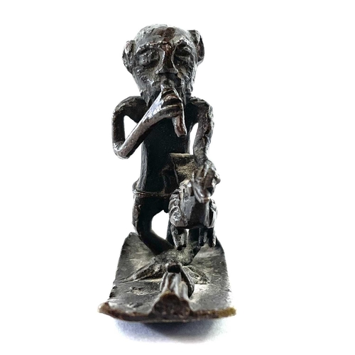 68 - An Ashanti bronze gold weight, 18th/19th century, modelled as a musician holding a bird, height 4.5c... 