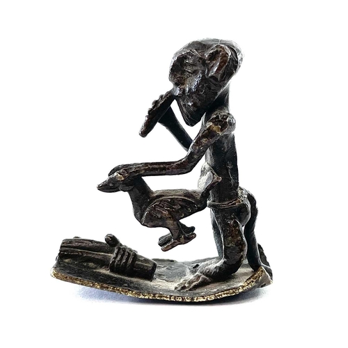 68 - An Ashanti bronze gold weight, 18th/19th century, modelled as a musician holding a bird, height 4.5c... 