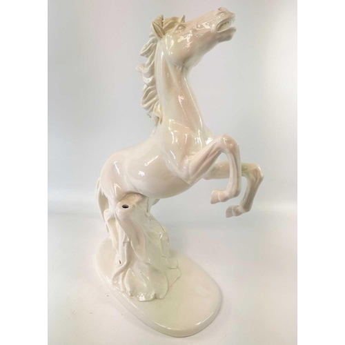 817 - An Italian pottery lamp base, modelled in the white as a rearing horse, lacks all fittings, height 5... 