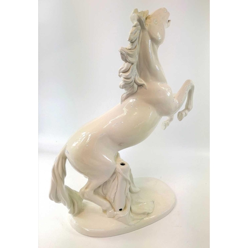 817 - An Italian pottery lamp base, modelled in the white as a rearing horse, lacks all fittings, height 5... 