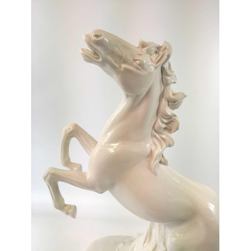 817 - An Italian pottery lamp base, modelled in the white as a rearing horse, lacks all fittings, height 5... 