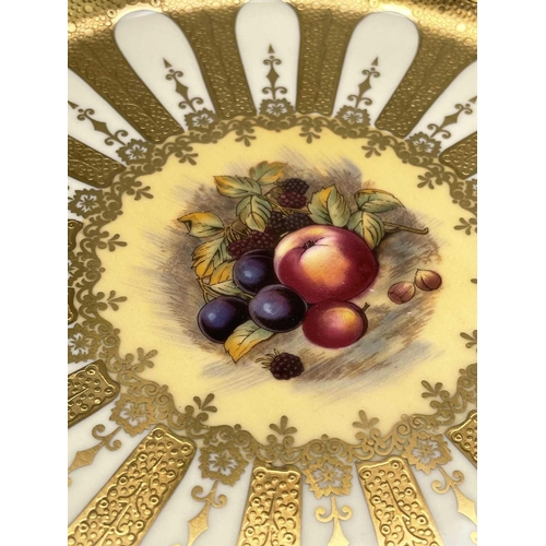 834 - An Aynsley fruit decorated porcelain plate, with a rich wide etched gilt border, diameter 27cm.