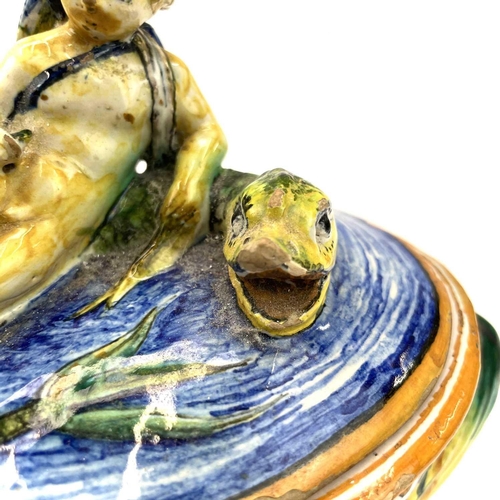 838 - A late 19th century Cantagalli maiolica bowl and cover with eros on a dolphin and twin shell handles... 