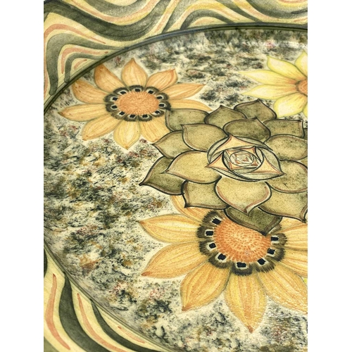 839 - Adrian Brough, A studio pottery platter, with flower painted decoration within a waved border, initi... 