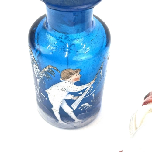 863 - A Mary Gregory enamelled blue glass scent bottle decorated with a boy holding a gun height 9cm toget... 