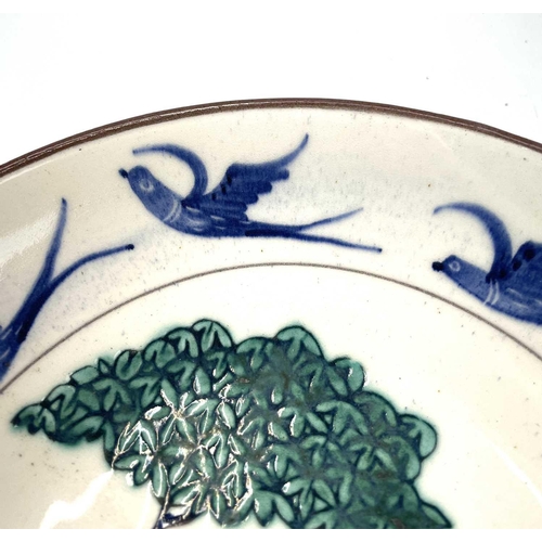 890 - An Alan Brough studio pottery dish, the centre decorated with a tree and birds, within a bird decora... 