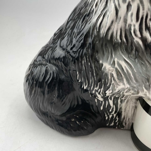 895 - A Beswick fireside advertising figure of the Dulux dog, with its front paw resting on a tin of paint... 