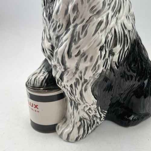 895 - A Beswick fireside advertising figure of the Dulux dog, with its front paw resting on a tin of paint... 