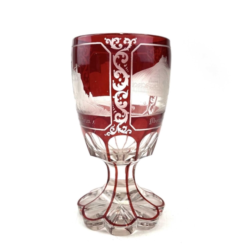 898 - A Bohemian red overlay glass goblet, circa 1880, engraved with three titled views, height 15cm.