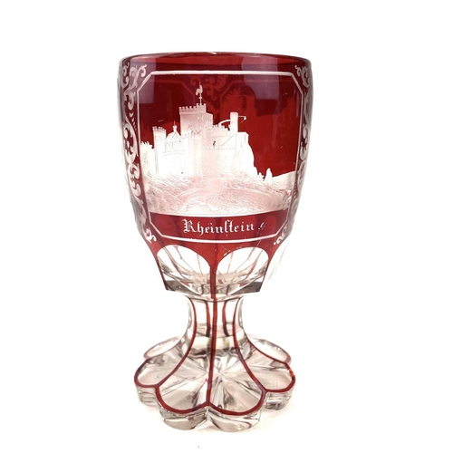 898 - A Bohemian red overlay glass goblet, circa 1880, engraved with three titled views, height 15cm.