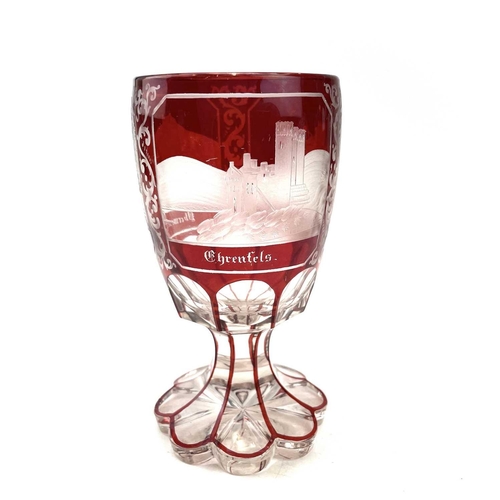 898 - A Bohemian red overlay glass goblet, circa 1880, engraved with three titled views, height 15cm.