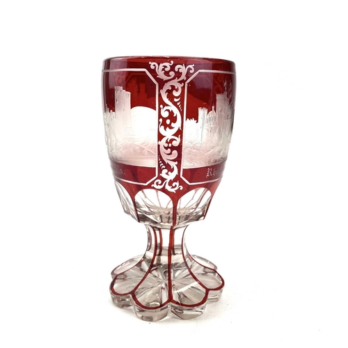 898 - A Bohemian red overlay glass goblet, circa 1880, engraved with three titled views, height 15cm.