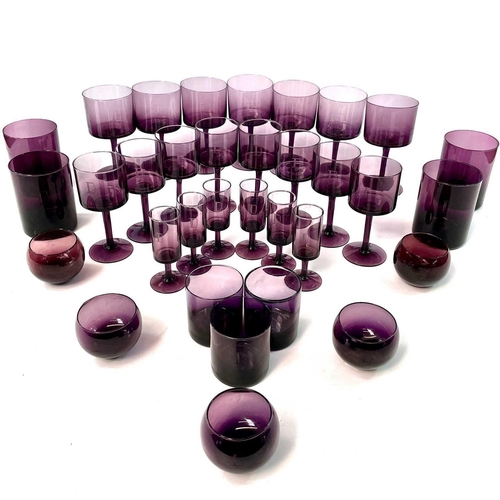 939 - A part suite of amethyst table glassware, mid 20th century, comprising seven red wines, eight white ... 