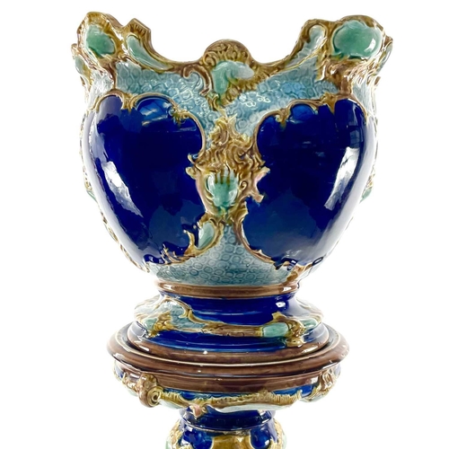 943 - A French Majolica jardiniere and stand, circa 1900, with moulded decoration on a blue ground, height... 