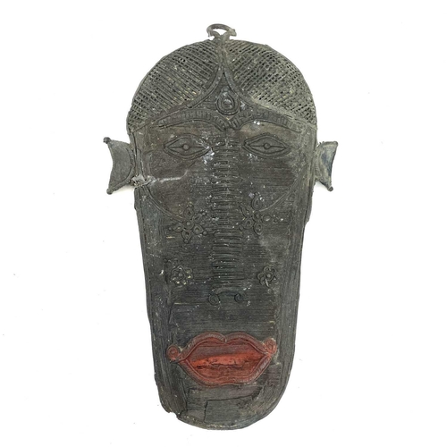 98 - An unusual African Benin type bronze wall mask, with red painted lips, height 32cm.