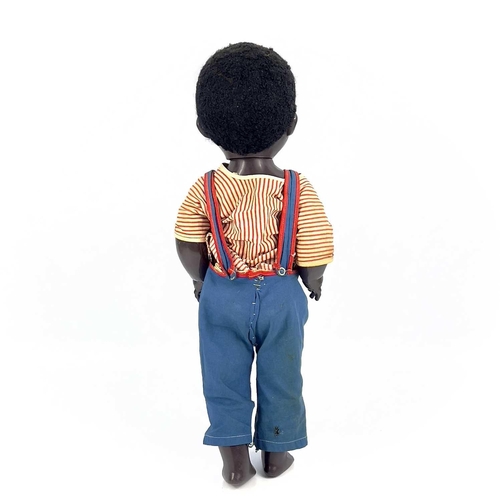 757 - A Black Celluloid Mechanical Walking, Closing Eyes Doll. Height 52cm, dressed in dungarees and red a... 