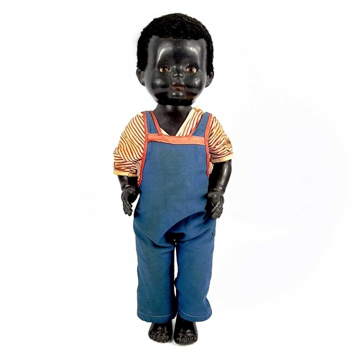 757 - A Black Celluloid Mechanical Walking, Closing Eyes Doll. Height 52cm, dressed in dungarees and red a... 