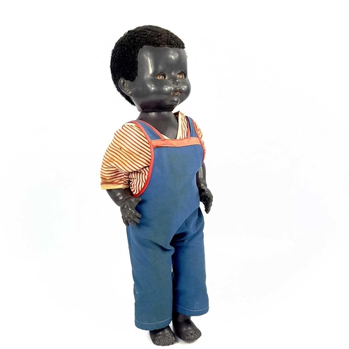 757 - A Black Celluloid Mechanical Walking, Closing Eyes Doll. Height 52cm, dressed in dungarees and red a... 