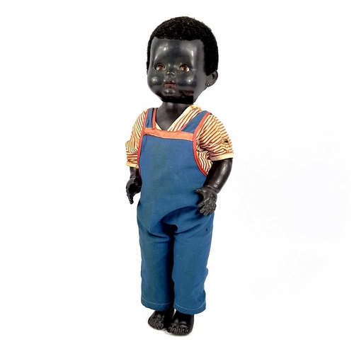 757 - A Black Celluloid Mechanical Walking, Closing Eyes Doll. Height 52cm, dressed in dungarees and red a... 