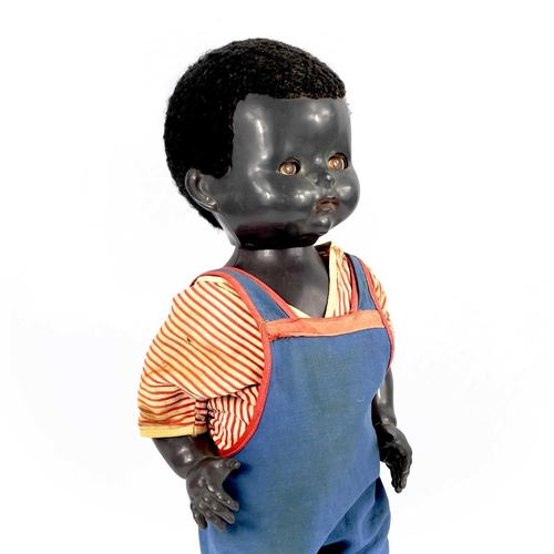 757 - A Black Celluloid Mechanical Walking, Closing Eyes Doll. Height 52cm, dressed in dungarees and red a... 