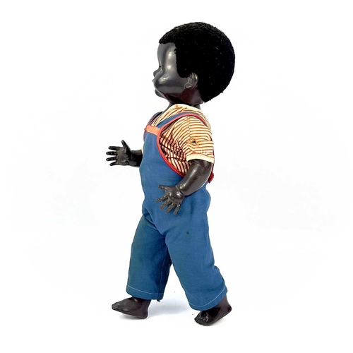 757 - A Black Celluloid Mechanical Walking, Closing Eyes Doll. Height 52cm, dressed in dungarees and red a... 