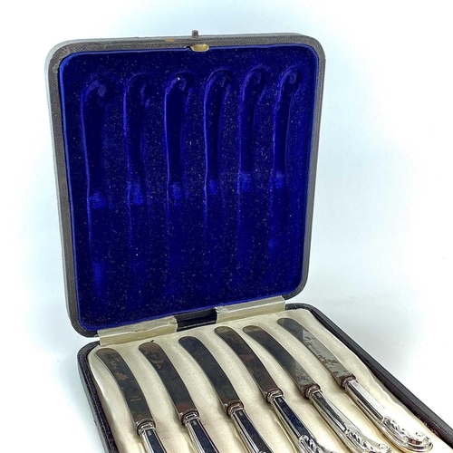 110 - A George V silver cased set of leaf scroll pistol filled handled butter knives Maker GHB, Sheffield ... 